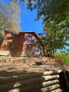 una casa de madera con una escalera delante de ella en Vine para Quedarme en San Martín de los Andes