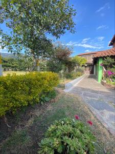 a garden with flowers and a building with a tree at MALAVI Cabaña Nobsa in Nobsa