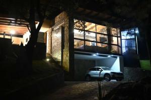 a car parked in front of a building at night at Cabaña de la Cascada in Mazamitla