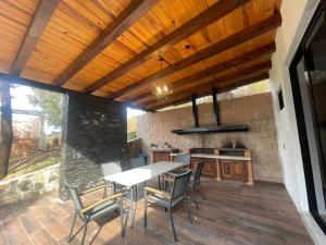 an outdoor kitchen with a table and chairs on a patio at Cabaña de la Cascada in Mazamitla