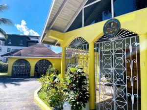 a yellow building with a gate in front of it at Yancey Largo Villa with Private Pool in Montego Bay