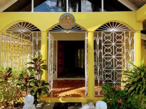 an entrance to a yellow house with a gate at Yancey Largo Villa with Private Pool in Montego Bay