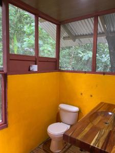 La salle de bains est pourvue de toilettes et d'une table en bois. dans l'établissement Finca la Bonita, Playa Carate, à Carate