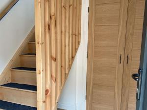 a staircase with a wooden door next to a stair case at The Coach House in Fordingbridge