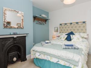 a bedroom with a bed with a fireplace and a mirror at Moonbeam House in Freshwater