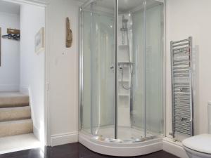 a glass shower in a bathroom with a toilet at Moonbeam House in Freshwater