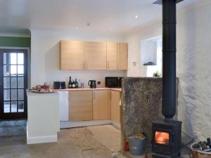 a kitchen with a stove in the middle of a room at The Calving Shed in Neilston