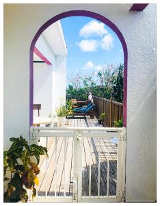 an arched doorway to a balcony with a person sitting on a chair at Villa GAIA in Les Trois-Îlets
