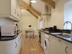 a kitchen with a washer and dryer on the counter at The Granary in Tiverton