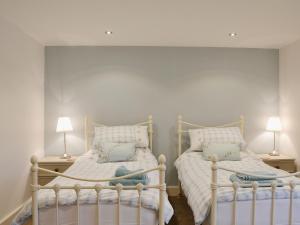 two twin beds in a room with two lamps at The Granary in Tiverton