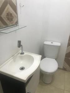 een badkamer met een wit toilet en een wastafel bij Cantinho da Nega - AP INTEIRO - IMPOSTOS E TAXAS INCLUSOS in São Vicente