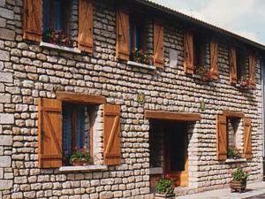 a brick building with wooden windows and potted plants at Gîte Saulmory-Villefranche, 4 pièces, 6 personnes - FR-1-585-15 