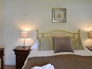 a bed with two pillows on it in a bedroom at Clematis Cottage in Burnsall