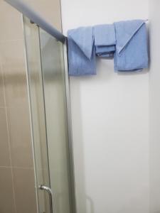 uma toalha azul está pendurada na porta do chuveiro em Comfy Guest Rooms em Port Antonio