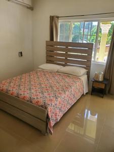 a bedroom with a bed and a large window at Comfy Guest Rooms in Port Antonio