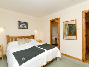 a bedroom with a bed with a black and white blanket at Seabird Cottage in Broadford