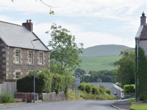 a street in a village with hills in the distance at Old Manse Annex in Town Yetholm