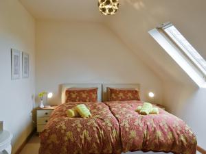 ein Schlafzimmer mit einem großen Bett im Dachgeschoss in der Unterkunft Honey Cottage in Newland