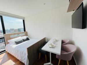 ein kleines Zimmer mit einem Bett, einem Tisch und Stühlen in der Unterkunft Apartaestudio en el Chico in Bogotá