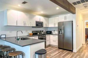 a kitchen with white cabinets and a stainless steel refrigerator at Hillside Silverlake - Echo Park and Free Parking in Los Angeles