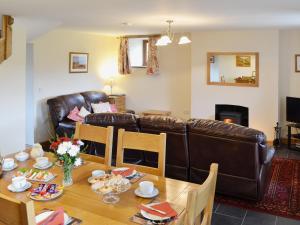 a living room with a table and a leather couch at Llechwedd Mawr in Talybont