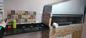 a kitchen with a brick counter top with a stove at SUÍTE - R&P - Centro in Peruíbe