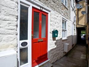 a red door on the side of a building at Applebee Cottage in Bridport