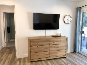 een flatscreen-tv aan de muur met een houten dressoir bij Silverlake and Echo Park - 6min to Downtown and Hollywood - in Los Angeles