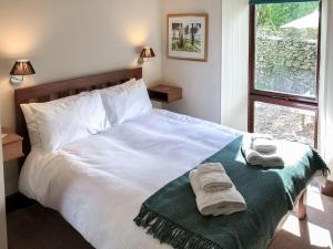 1 dormitorio con 1 cama grande y toallas. en Yew Tree Farm, en High Newton