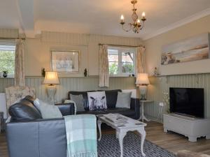 a living room with a couch and a tv at Broadoak Barn in Ellesmere