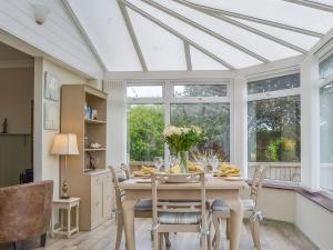 a conservatory dining room with a table and chairs at Broadoak Barn in Ellesmere