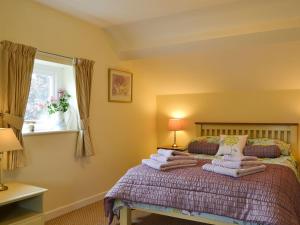 ein Schlafzimmer mit einem Bett mit einem Stapel Handtücher drauf in der Unterkunft Broadoak Barn in Ellesmere