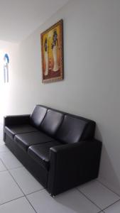 - un canapé noir dans une chambre avec une photo sur le mur dans l'établissement Pousada Recanto Gentil, à Triunfo