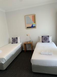 a room with two beds and a table with a lamp at Nagambie Waterfront Motel in Nagambie