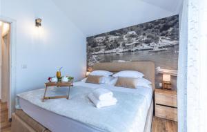 een slaapkamer met een bed met een schilderij aan de muur bij Nice Home In Sestanovac With Kitchen in Šestanovac