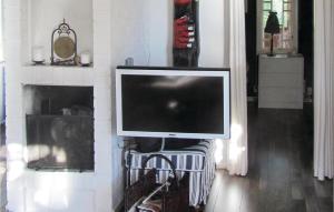a television on a stand in a living room with a fireplace at Nice Home In Vstervik With 2 Bedrooms And Wifi in Västervik