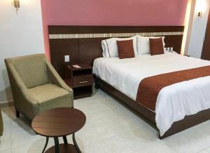 Habitación de hotel con cama y silla en Ivissa Hotel en Santiago Pinotepa Nacional