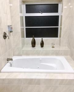 2 jarrones sentados en un baño con bañera en Ivissa Hotel en Santiago Pinotepa Nacional