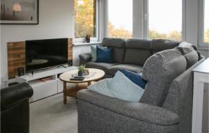 ein Wohnzimmer mit einem Sofa und einem TV in der Unterkunft Ferienhaus Zum Teichtal M in Hainrode