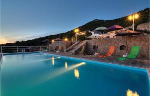 una piscina con 2 sillas y un edificio en Gorgeous Apartment In Stinica With House Sea View, en Stinica