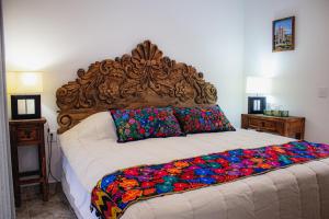 サンミゲル・デ・アジェンデにあるBELLAS VILLAS VILLA SOL HERMOSA CASA y ACCECIBLE PRECIOの木製のヘッドボードが付いた大きなベッドのある寝室