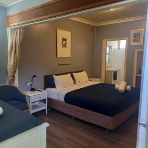 una habitación de hotel con 2 camas y una silla en Mount View Motel, en Bulahdelah