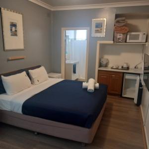 1 dormitorio con 1 cama grande y cocina en Mount View Motel, en Bulahdelah