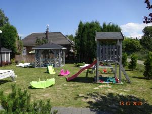 a yard with a playground with a slide and a swing set at Holiday home in Wiselka in Wisełka