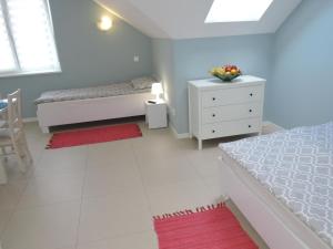 a white bedroom with a bed and a dresser and a drawer at Holiday home in Wiselka in Wisełka