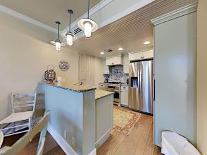 een keuken met witte kasten en een keukeneiland met een aanrecht bij Gulf Place Six Palms #2B - BBs Hideaway in Santa Rosa Beach