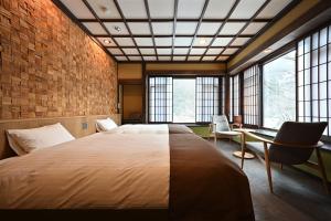 um quarto com uma cama grande e algumas janelas em Syoubun em Minakami