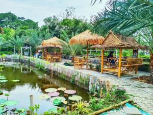 a restaurant with tables and chairs and a pond with lilies at Ban Ing Suan in Samutprakarn
