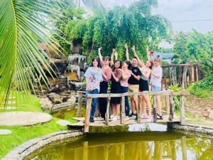 a group of people standing on a bridge over a pond at Floor river view in Cat Tien
