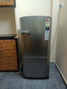 a stainless steel refrigerator in a kitchen next to a counter at ADVIK HOMESTAYS in Tirupati